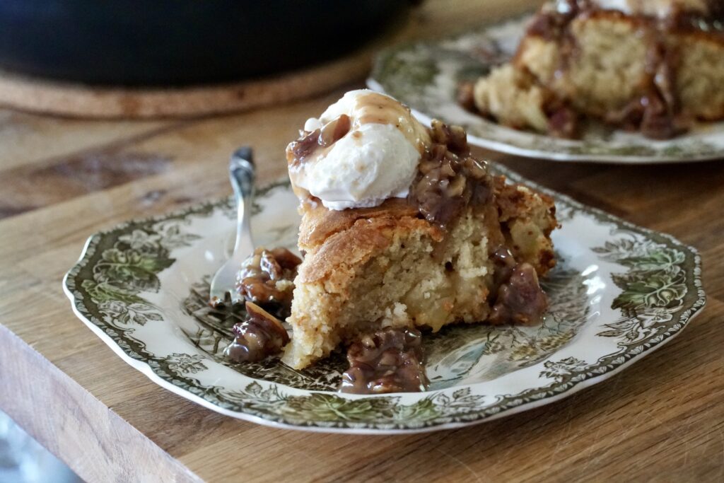 Apple Skillet Cake served with premium vanilla ice cream and a ladle of butter pecan sauce.