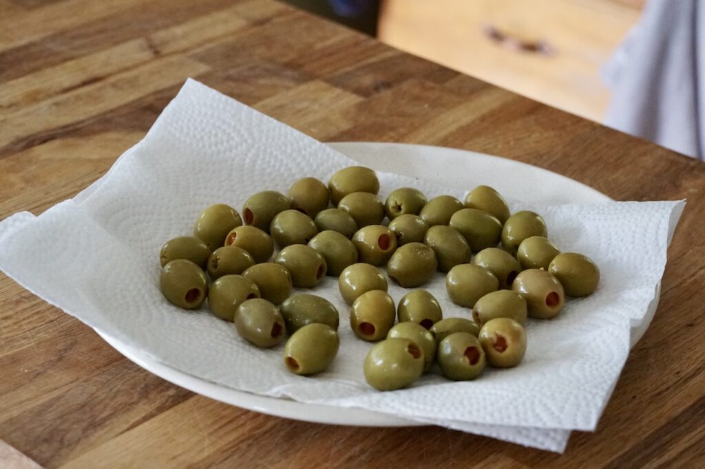 The strained olives resting on paper towels to remove excess liquid.