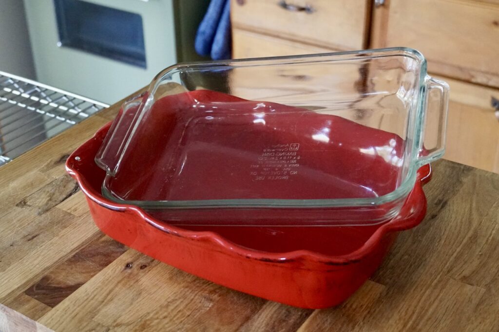 Two casserole dishes; one made from oven-safe earthenware the other from glass.