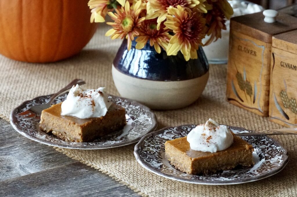 Pumpkin Pie Squares served on small dessert plates with a dollop of whipped cream.