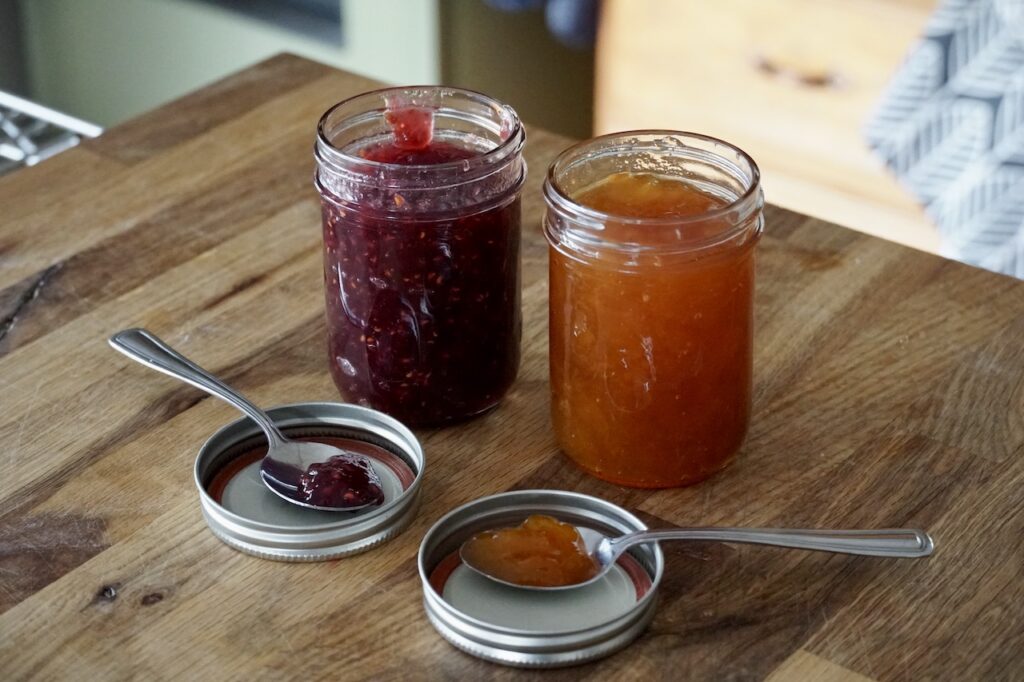 Bottles of raspberry and apricot jams.
