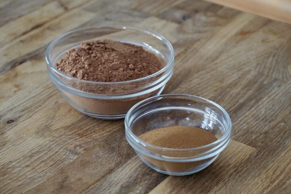 A bowl of premium cocoa powder and a bowl of espresso powder.