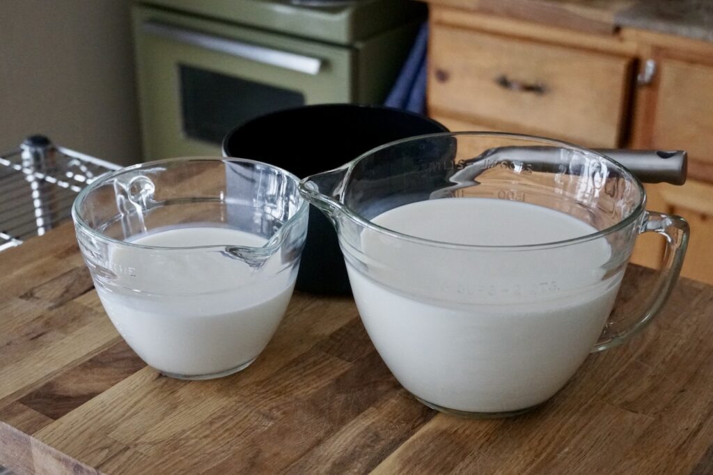 Large liquic measures filled with homogenized milk and half-and-half cream.