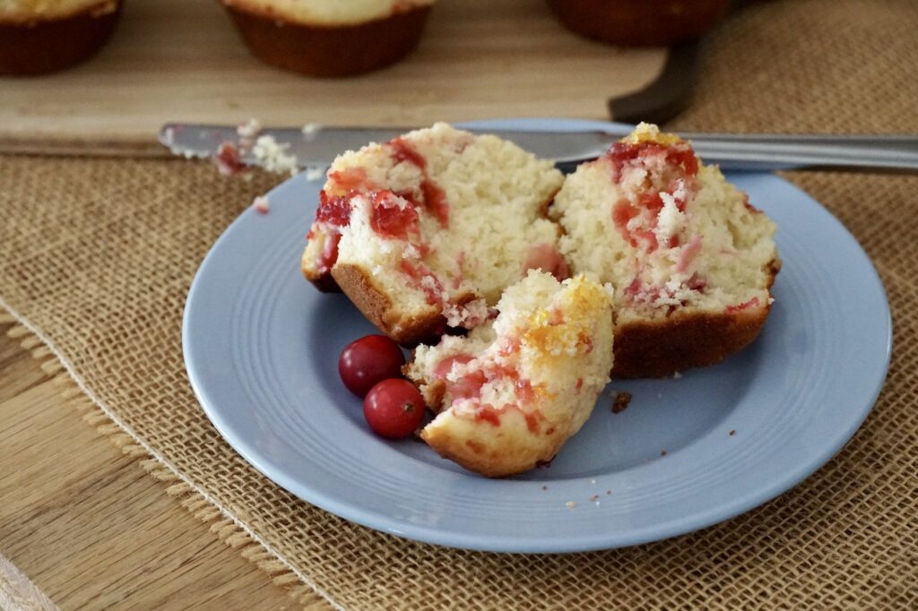 One of the cran-orange muffins cut open to reveal the fruit-swirled center.