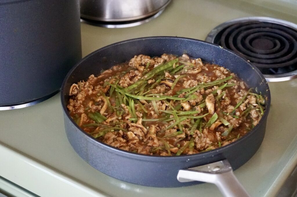 The finished Chinese meat sauce tossed with shiitake mushrooms and snow peas.