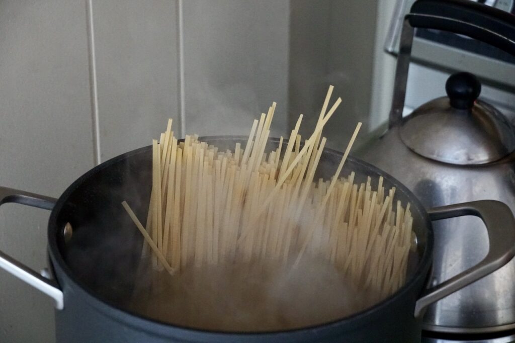A large stock pot containing the long linguine noodles.