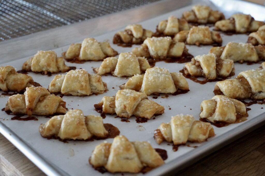 A baking tray of rugelach, freshly baked from the oven.