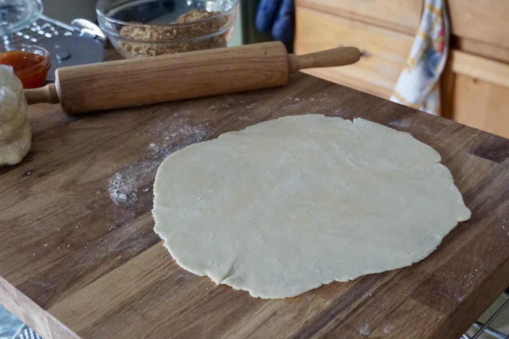 A disc of dough rolled out into a 10-inch circle.
