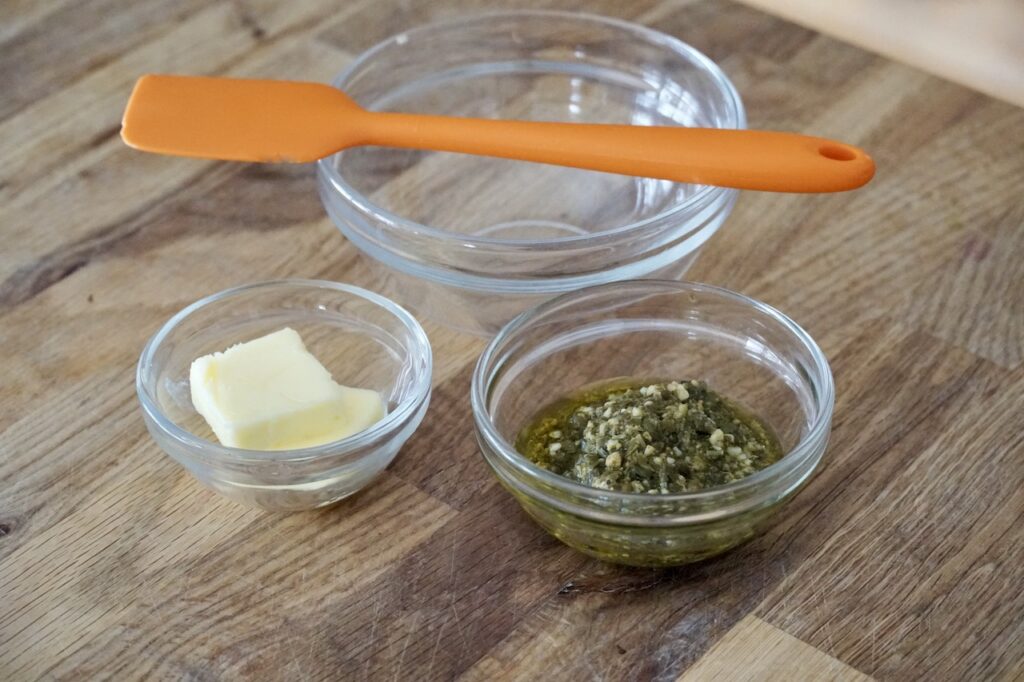 A bowl of pesto and butter ready to be stirred together.