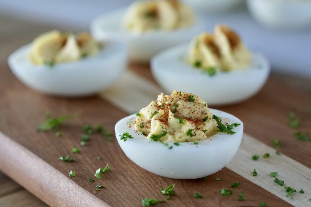 A deviled egg garnished with chopped parsley and paprika.