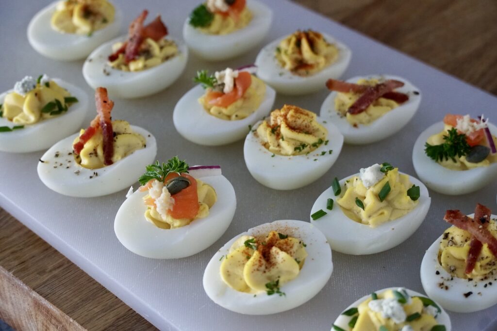 A serving board filled with assorted eggs from our CLASSIC DEVILED EGGS RECIPE.