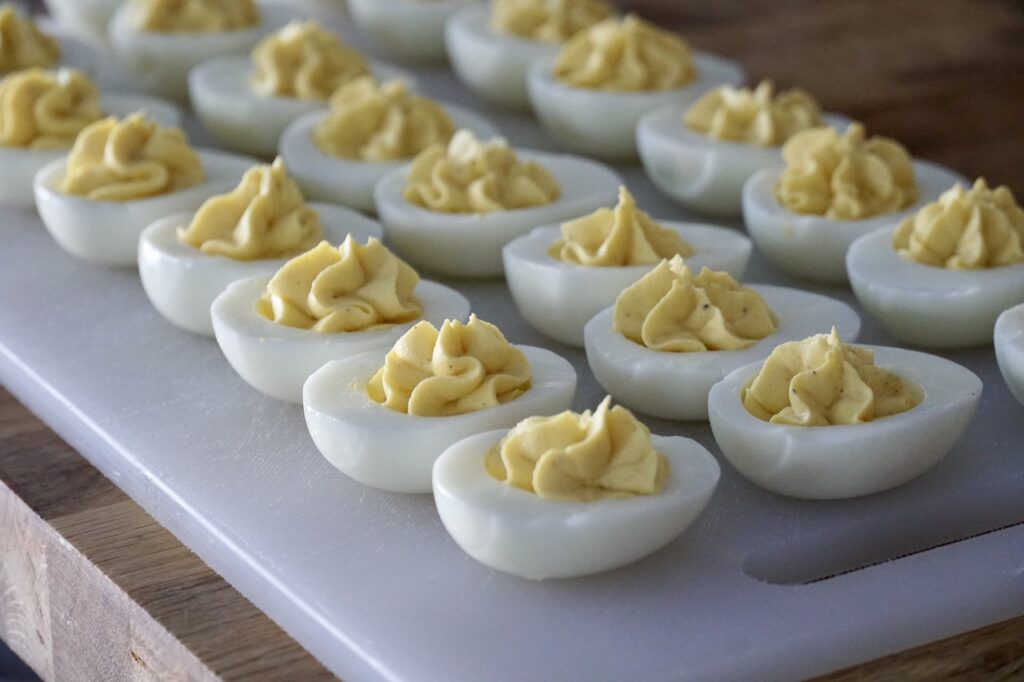 Halved hard boiled eggs filled with creamy deviled eggs fillingg.