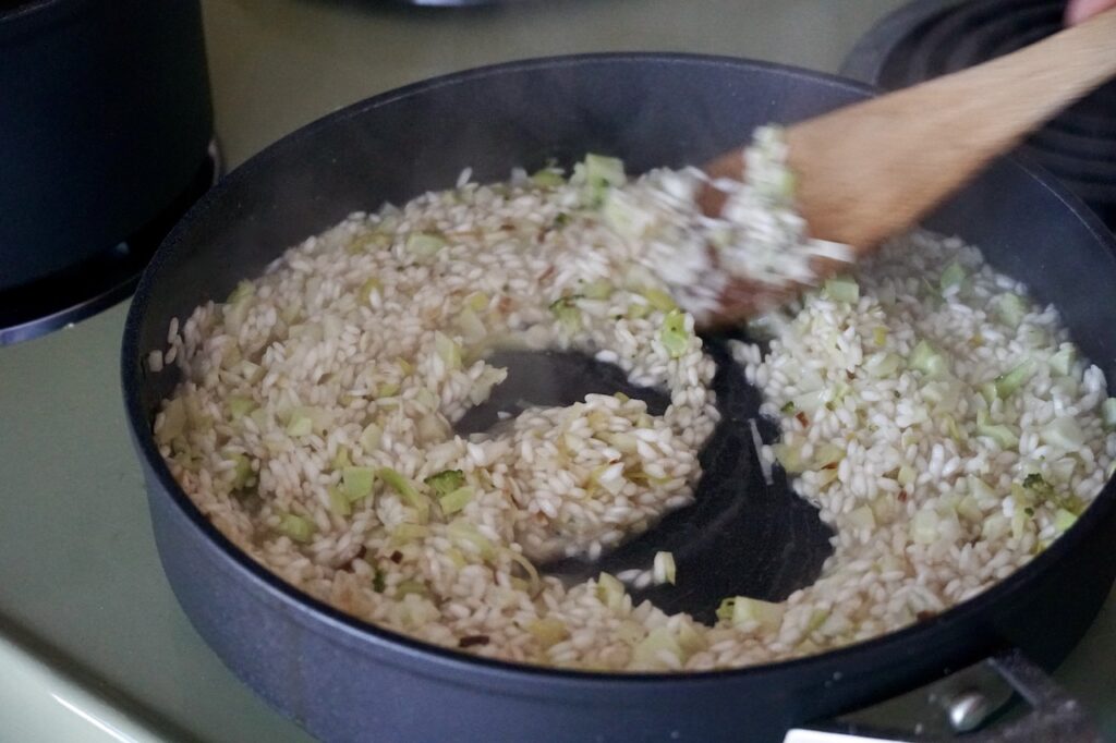 The rice is stirred slowly in the skillet