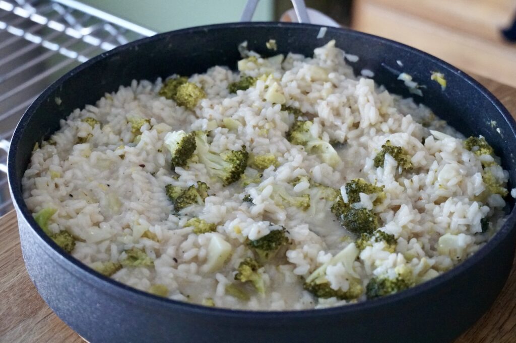 A large skillet filled with creamy broccoli risotto.