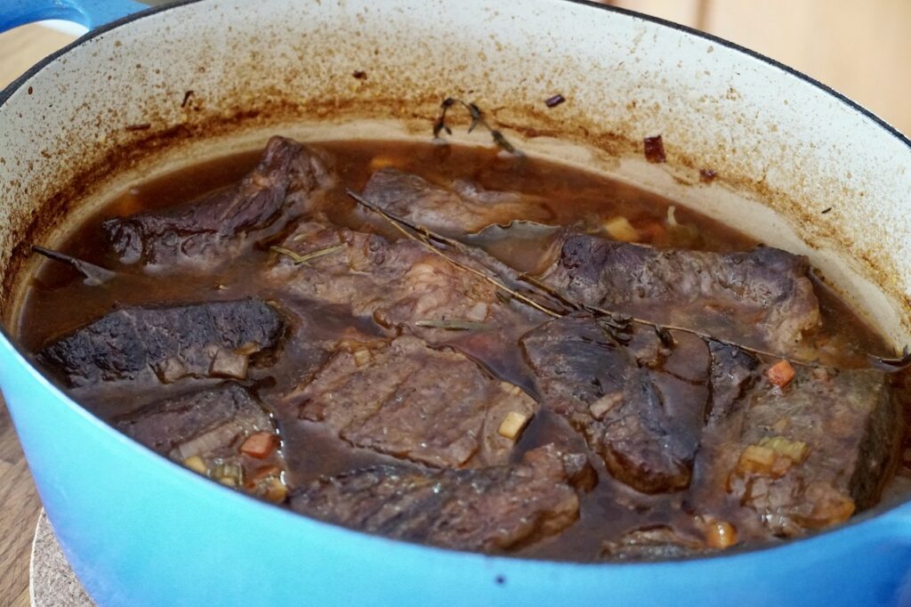 The pot of fully cooked braised beef ribs.