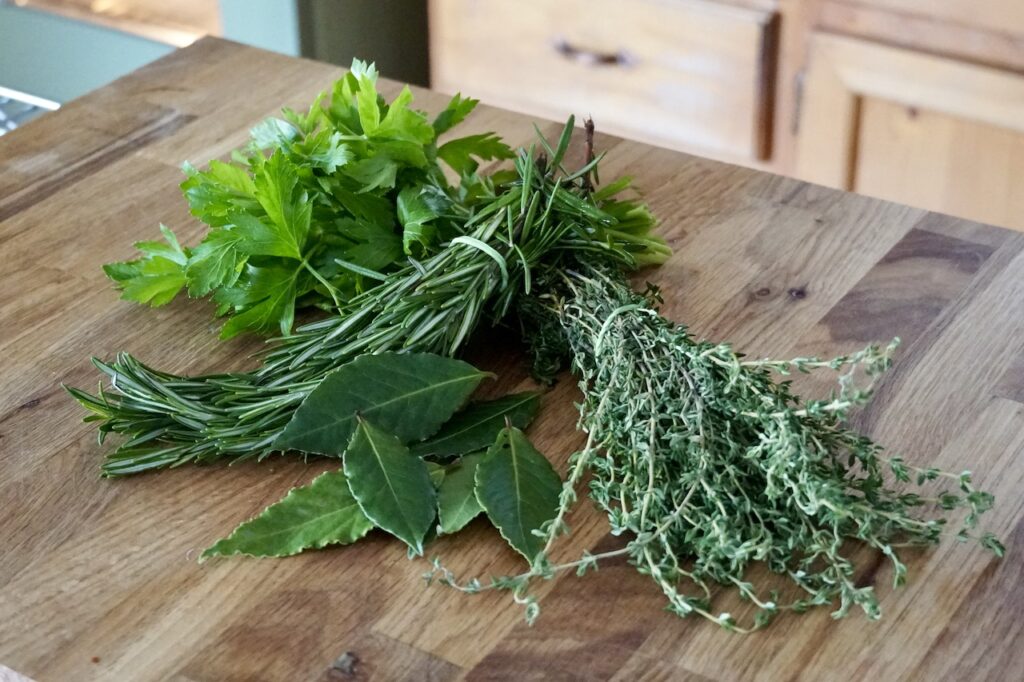 Bunches of fresh herbs including: parsley, rosemary, thyme and bay leaves.