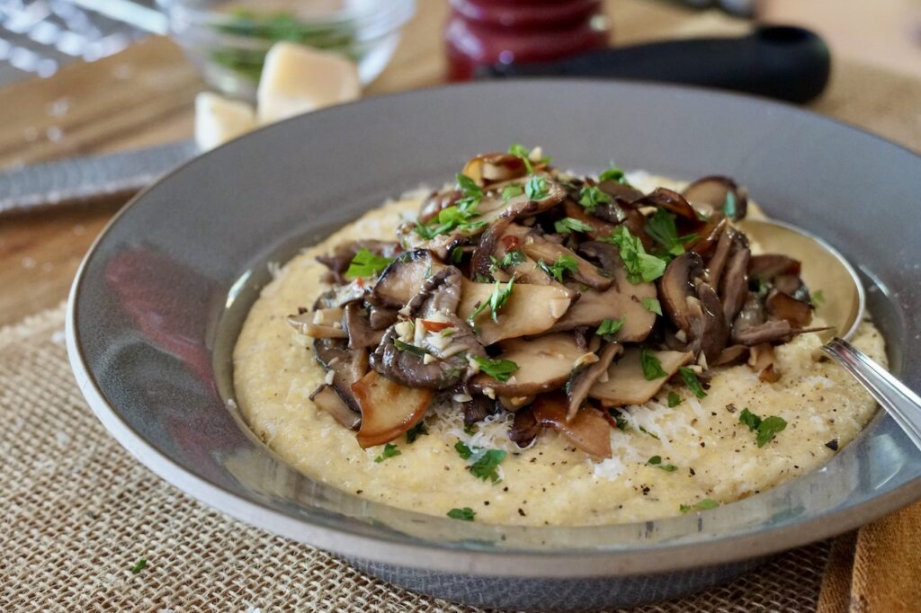 Creamy polenta with Parmesan topped with sauteéd mushrooms.