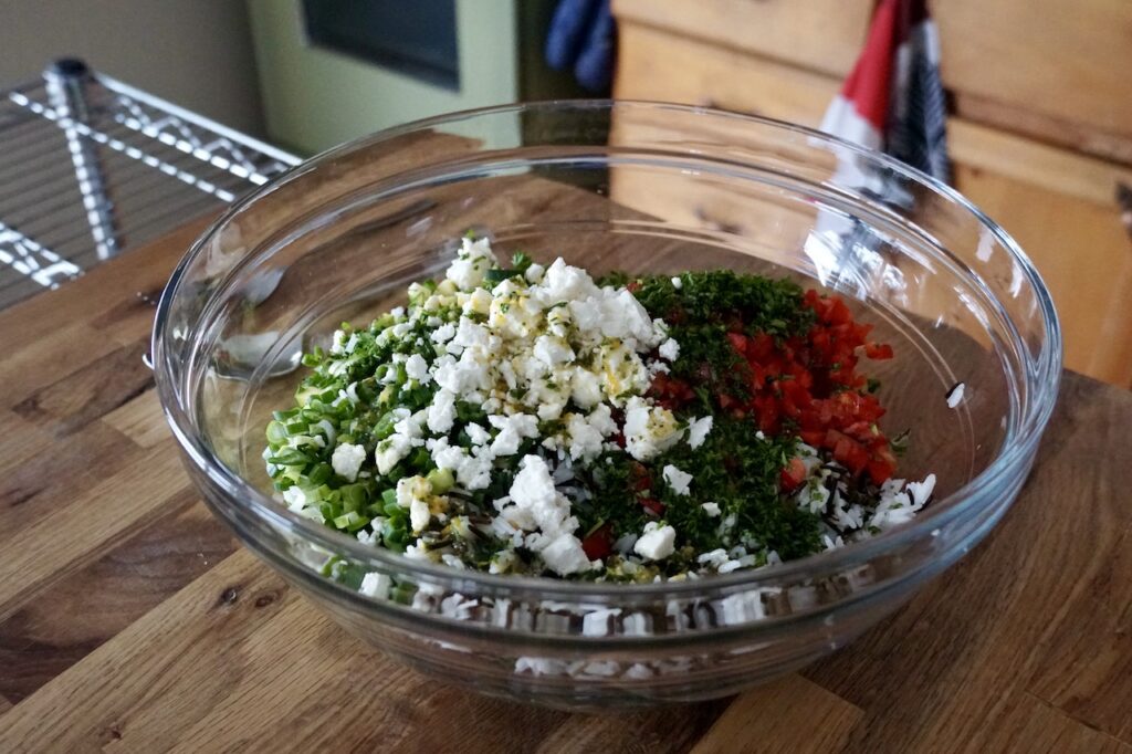 A large bowl containing all of the ingredients for the salad, ready to be tossed.