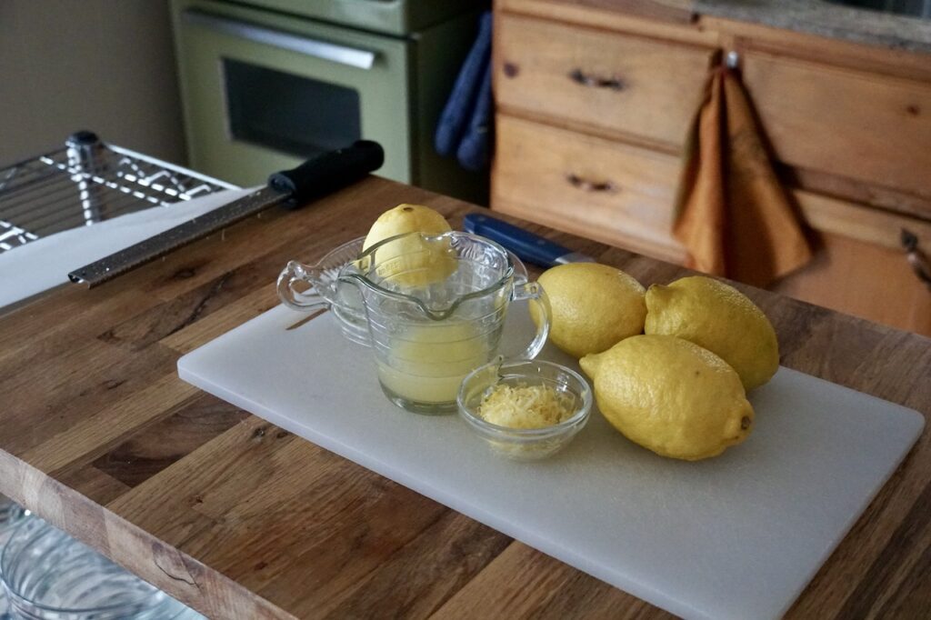 Fresh lemons sitting on a counter: zested and juiced.
