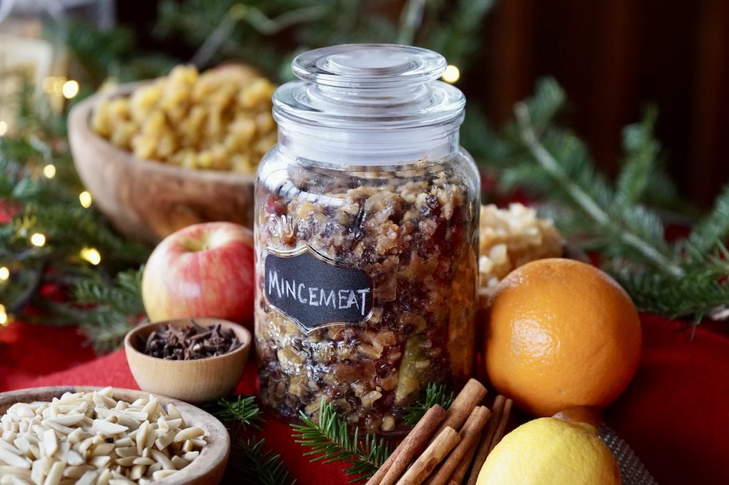 A large storage bottle filled with a homemade Festive Mincemeat Recipe.