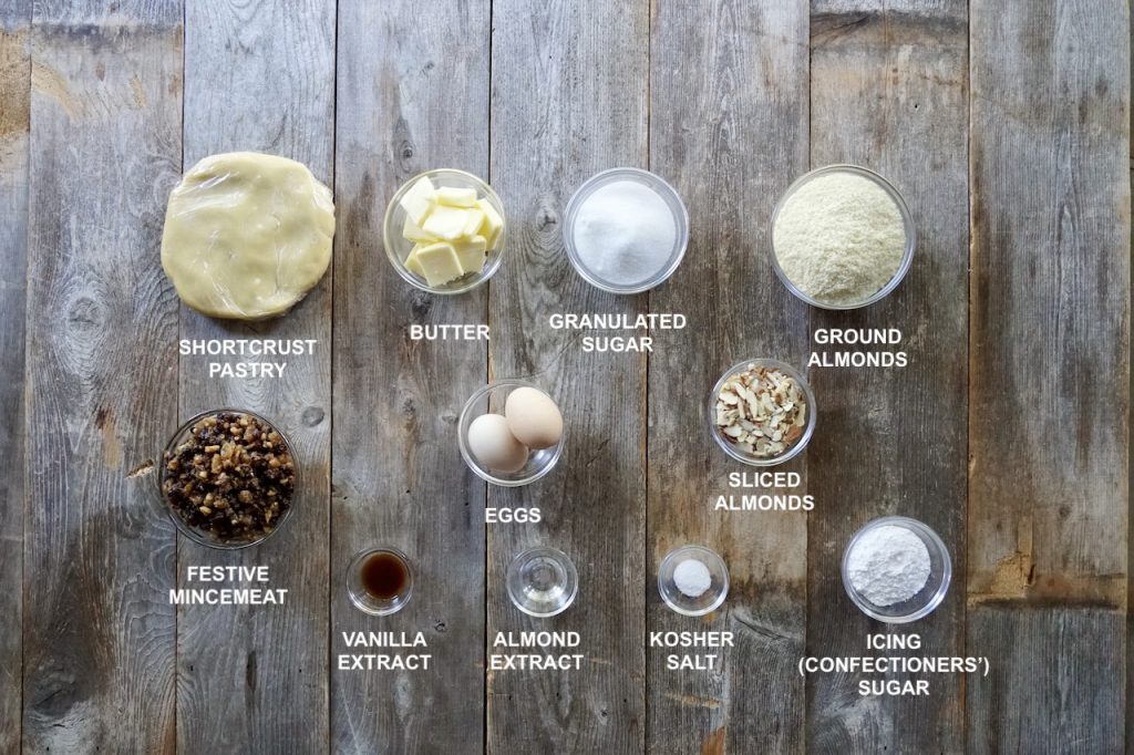 All of the ingredients needed to make a mincemeat frangipane tart including a disc of shortcrust pastry, mincemeat and items to create a creamy almond frangipane.