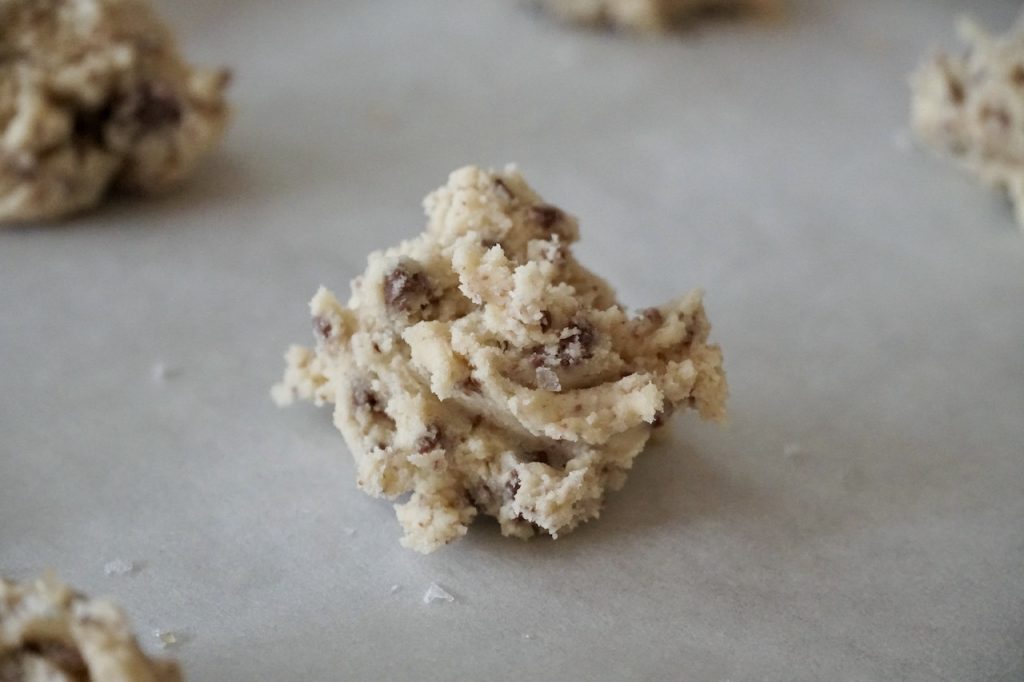 The shortbread cookies spooned onto a parchment paper lined cookie tray.