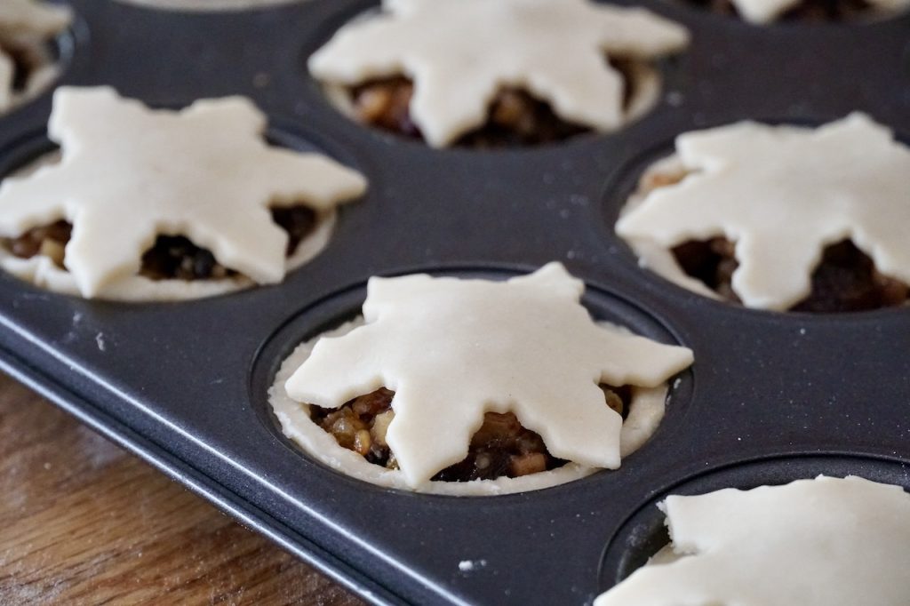 Each cup is topped with a pastry lid cut into a seasonal holiday motif.