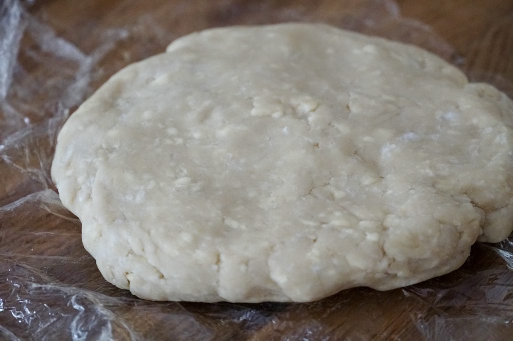 A disc of flaky, buttery homemade pastry dough.