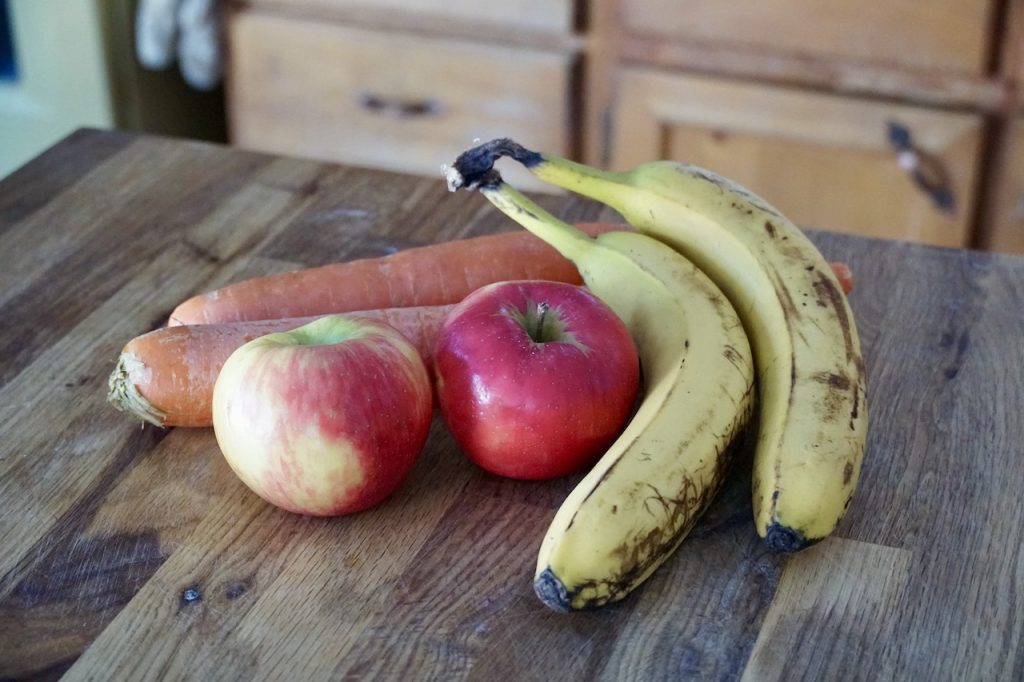 Fresh apples, bananas and carrots ready to be blended up in a healthy smoothie.