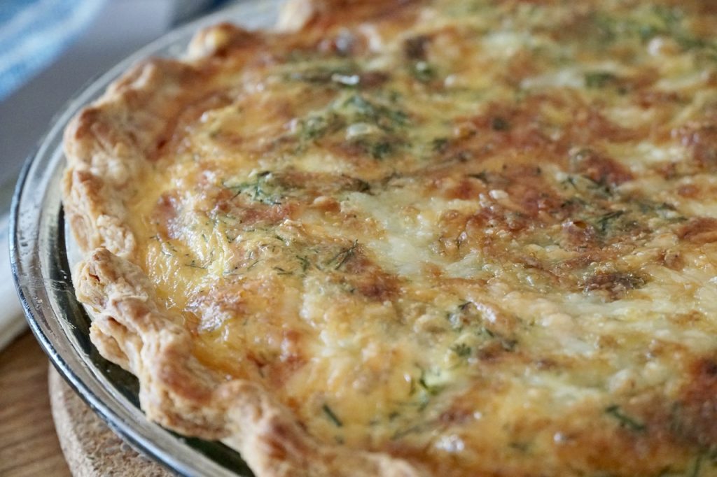 A close up of the cheesy topped, freshly-baked quiche.