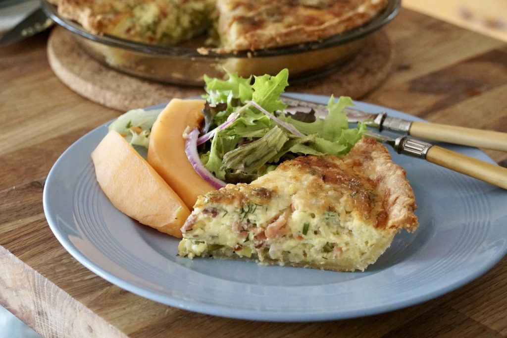Homemade Smoked Salmon Quiche served with a green salad and fresh fruit.