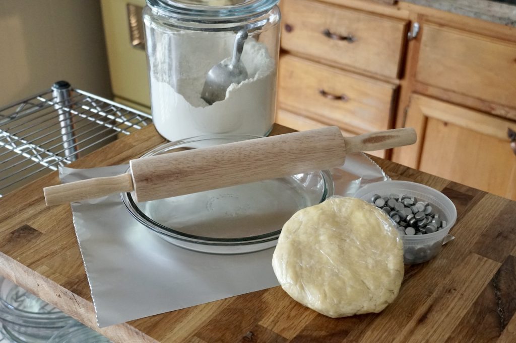 A disc of pie dough plus a pie plate, rolling pin, pie weights and parchment paper.