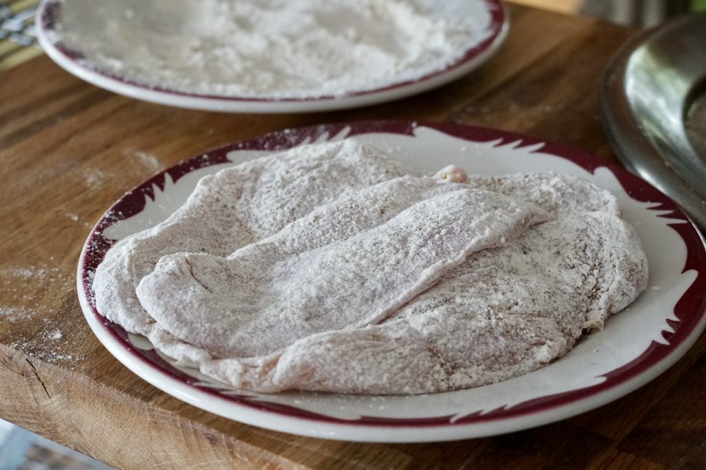 The chicken breasts seasoned and dredged in flour.