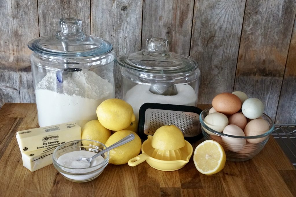 The various ingredients needed to make homemade lemon meringue pie laid out on the kitchen counter.