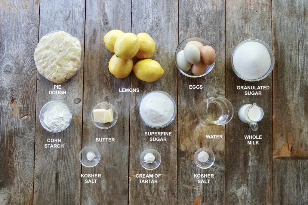 All of the ingredients for homemade lemon meringue pie include: pie dough, lemons, sugar, butter, corn starch and farm fresh eggs.