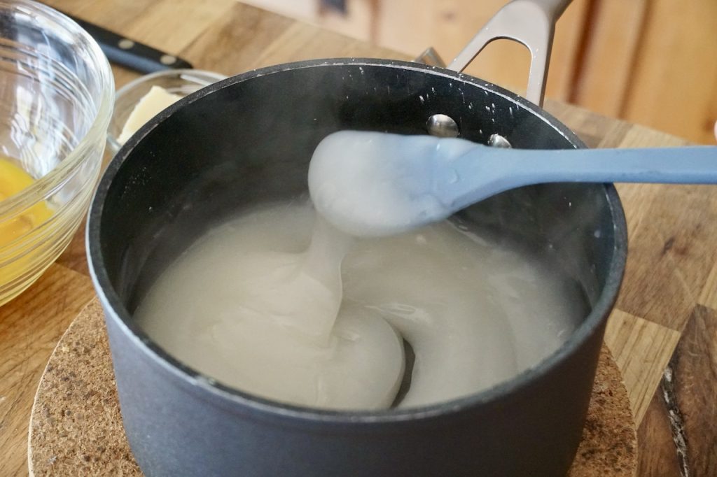 A pot with the creamy milk mixture before the egg yolks and lemon juice are added.