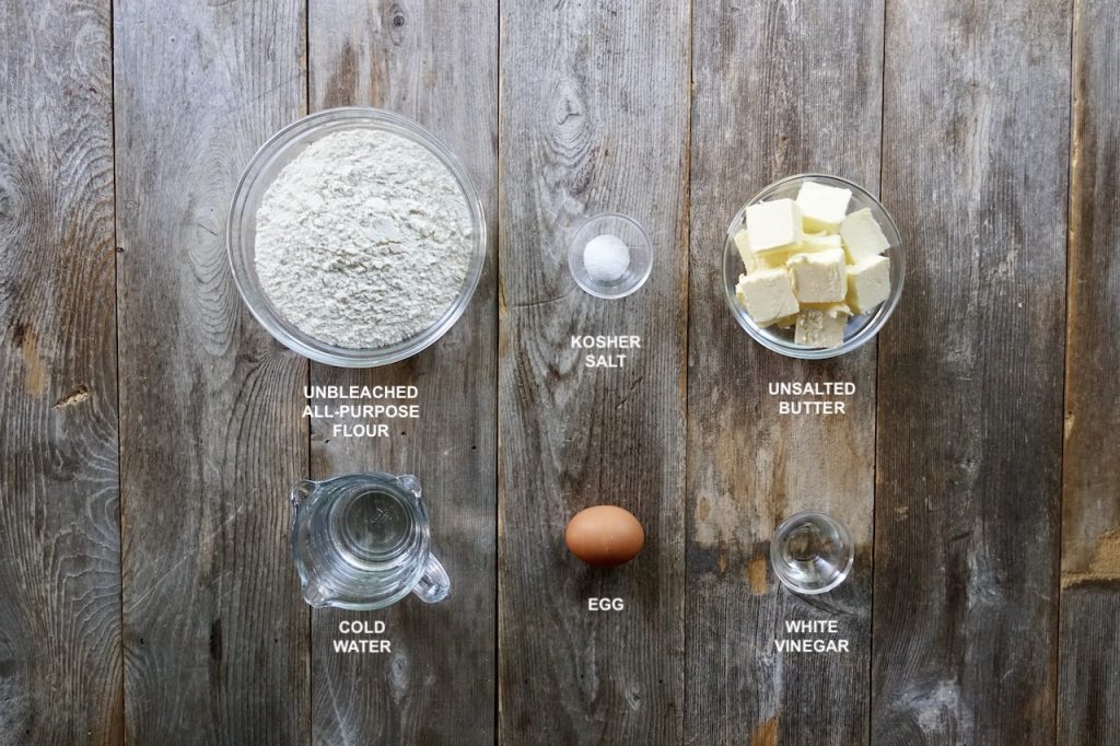 Ingredients for a homemade all-butter pie dough include: flour, butter, water, egg and white vinegar.