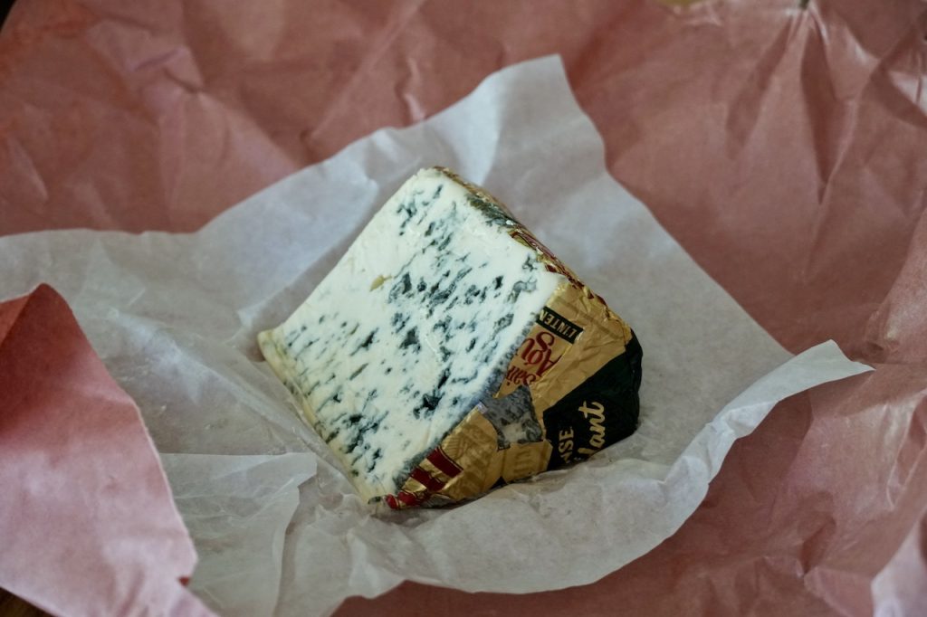 A wedge of Saint Agur French blue cheese.