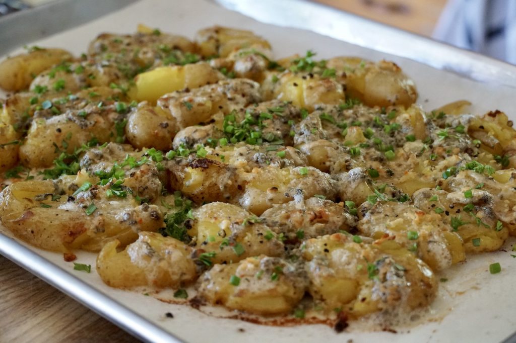 Fresh from the oven: crispy smashed potatoes topped with melted French blue cheese.