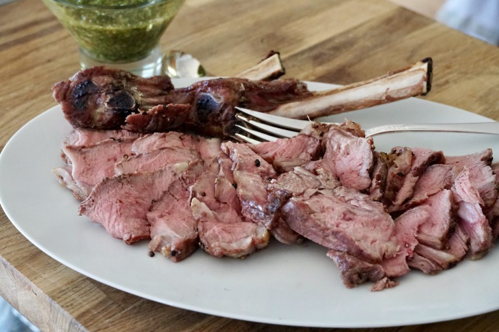 Grilled Veal Rib Chops, thinly sliced arranged on a large platter.