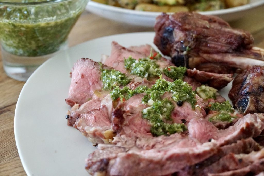 Grilled Veal Rib Chops topped with a spoonful or two of herbed chimichurri.
