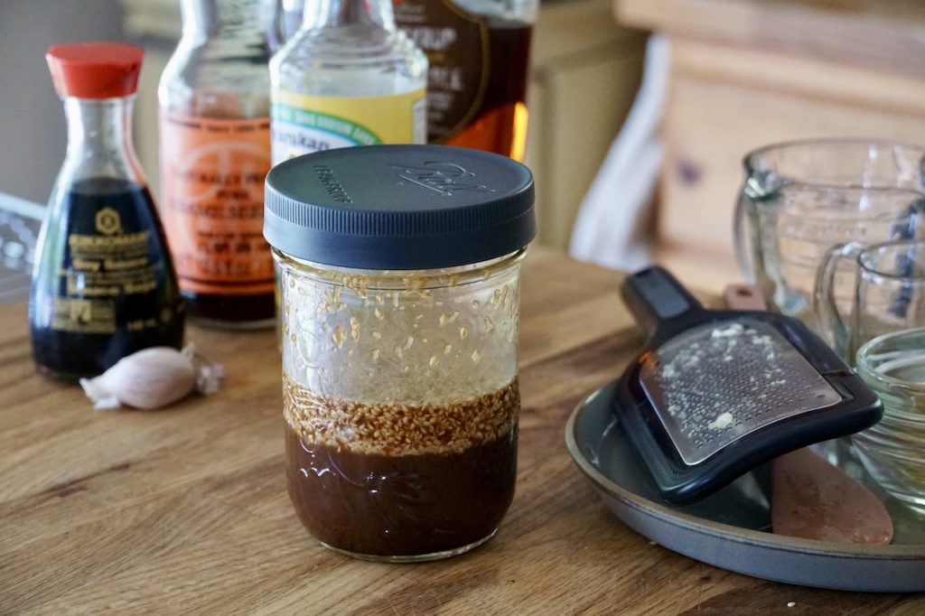 A Mason jar filled with an easy Asian dressing to go with the Healthy Quinoa Salad.