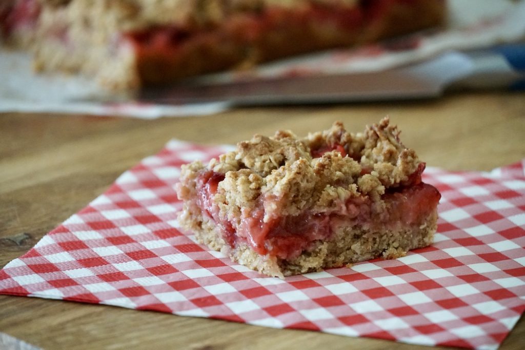 A Strawberry Rhubarb Crumble Square served on a paper dessert napkin.