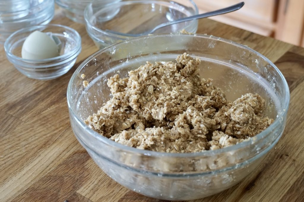A bowl containing the base dough and crumble topping for the dessert squares recipe.