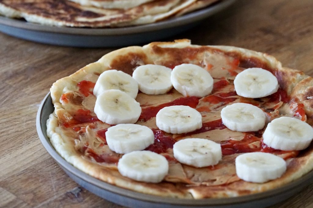 Easy Flatbread Recipe served for breakfast with peanut butter, jam and sliced bananas.