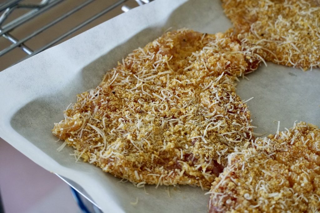 Freshly breaded slices of pork loin.