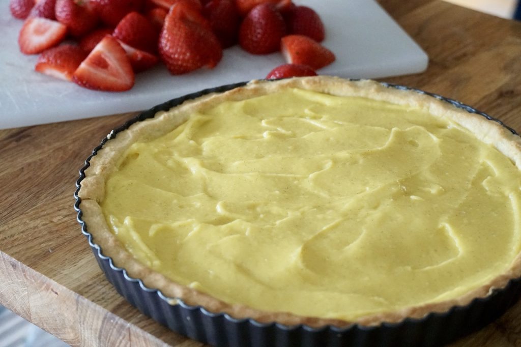 The tart shell filled with vanilla custard.