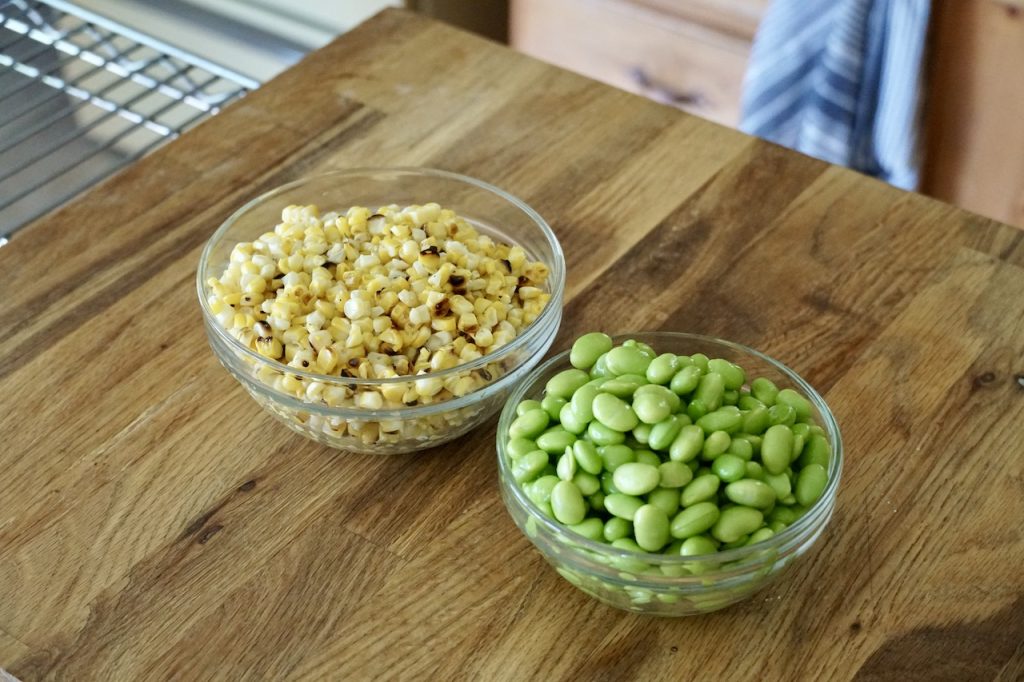 Bowls of grilled corn kernels and edamame.