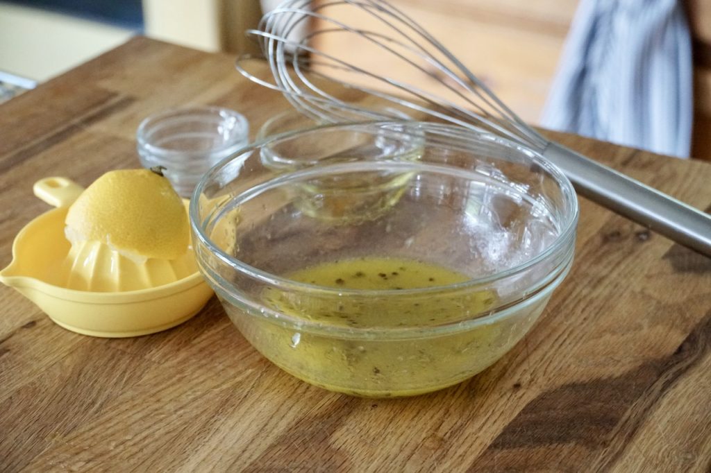 A bowl containing the tangy lemony vinaigrette.