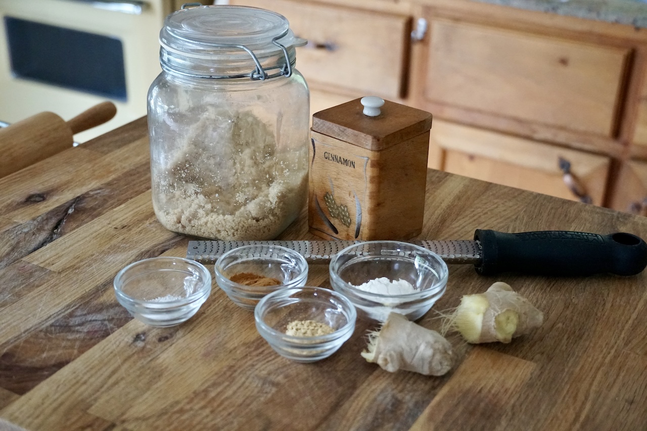 A container of brown sugar, a knob of gingers plus kosher salt, corn starch, cinnamon and ground ginger.